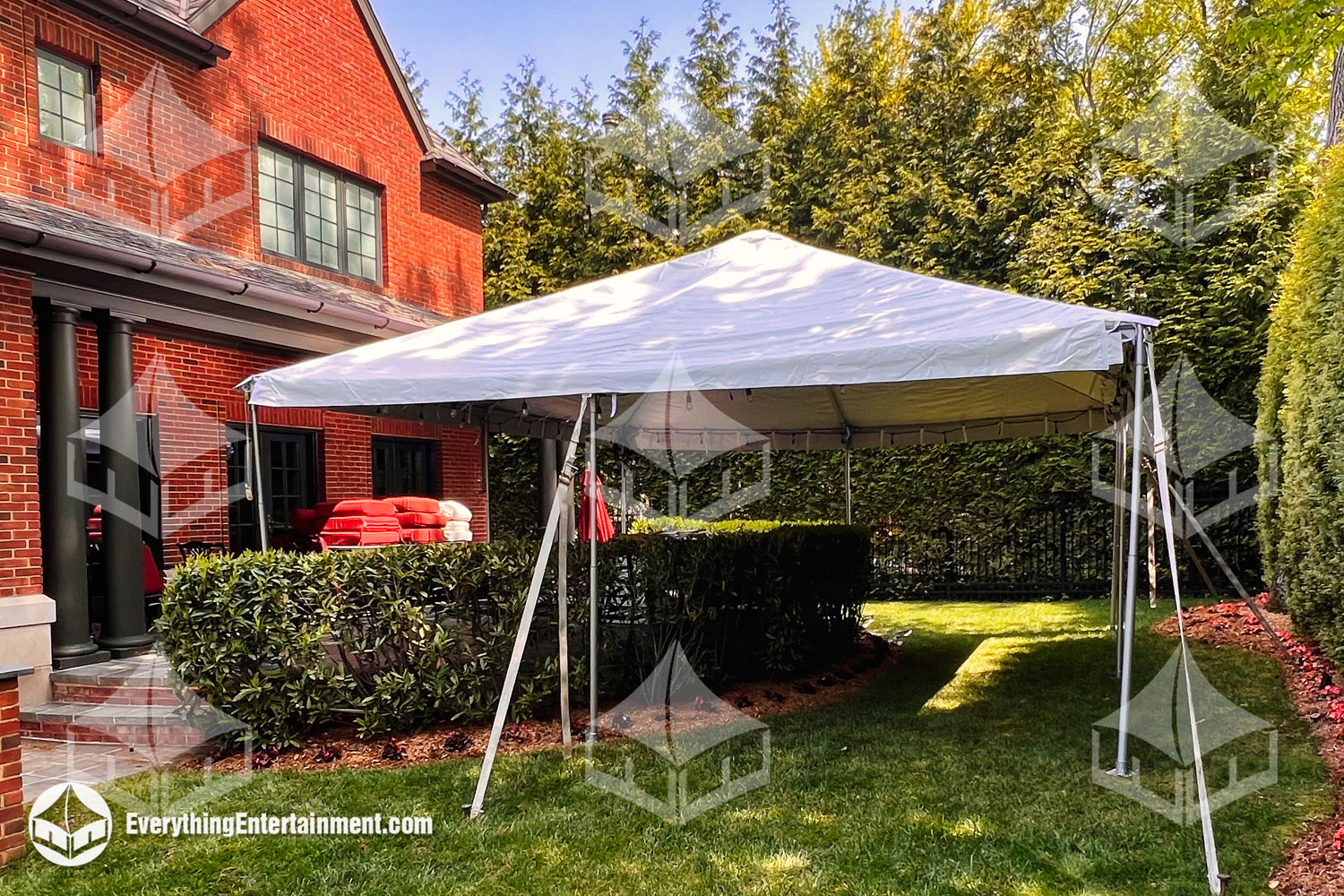 Backyard-party-tent 20x20 white top frame tent set up in backyard with greenery.