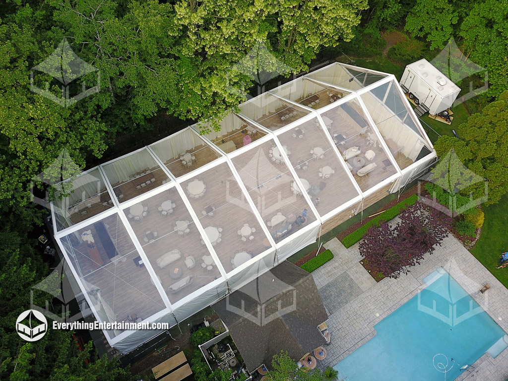clear wedding tent on tennis court Aerial view of a clear top wedding tent with a pool in the foreground.